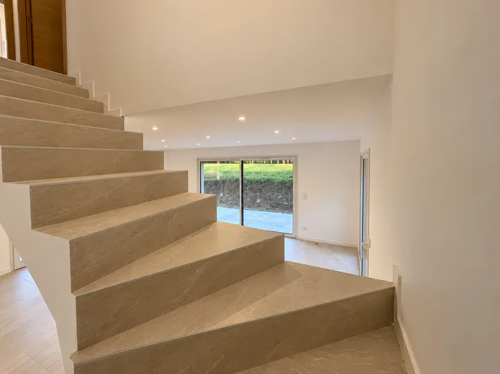 Escalier en pierre beige donnant sur le séjour