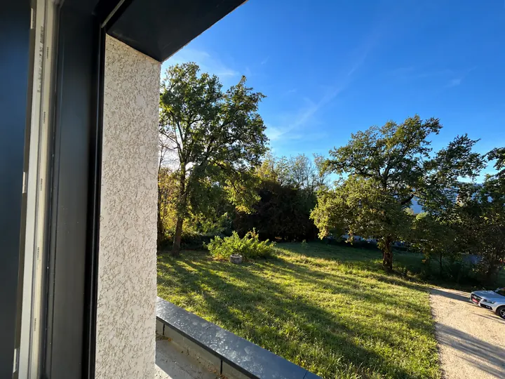 Vue sur le jardin ensoleillé depuis l’étage