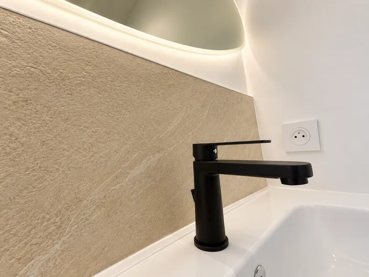 Lavabo et robinet noir sur pierre beige