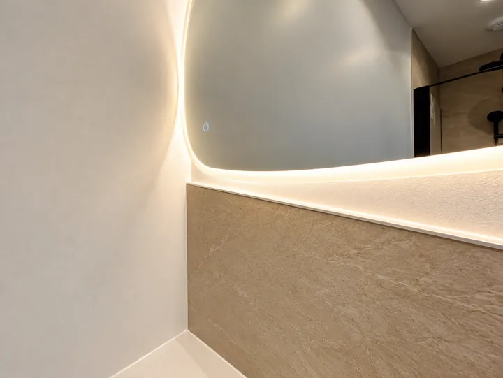 Miroir LED sur un mur en pierre chaleureuse