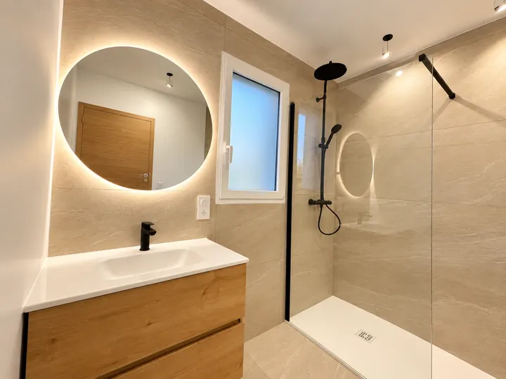 Salle de bains aux tons naturels, miroir rond