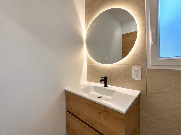 Salle de bains avec miroir rond lumineux