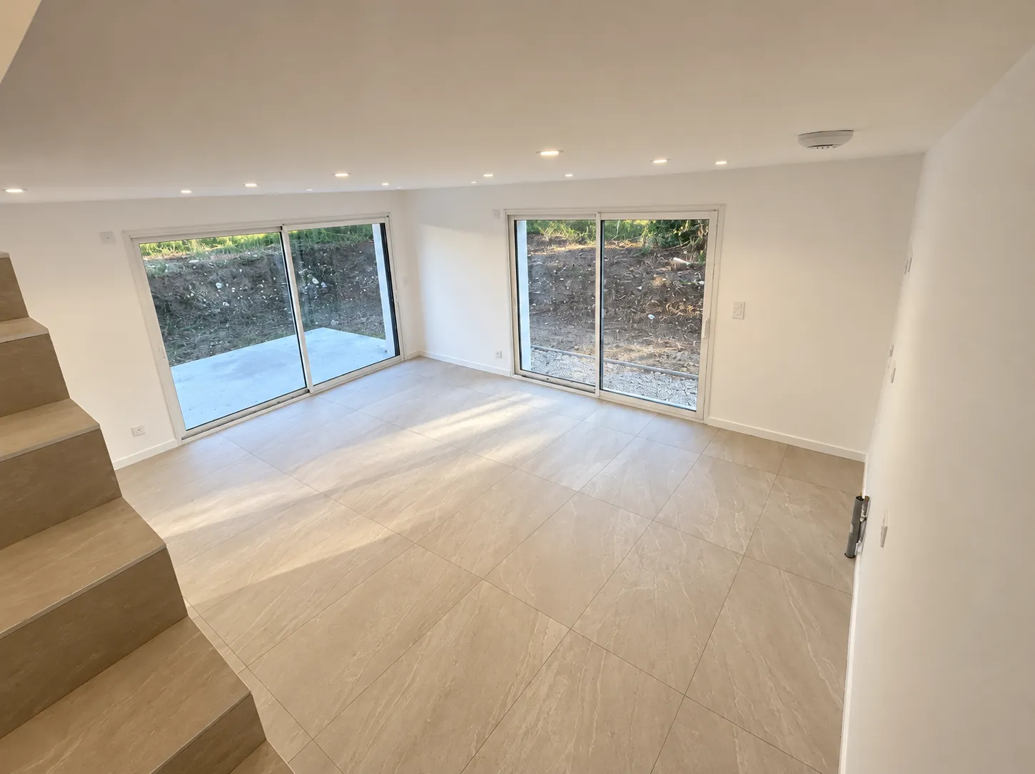 Séjour de la maison B avec baies vitrées