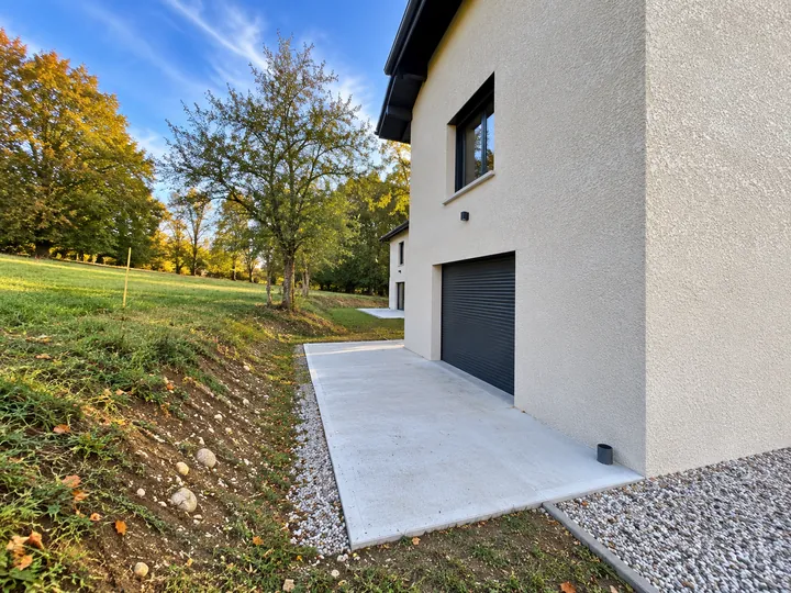 Pignon de la maison, garage et terrasse béton